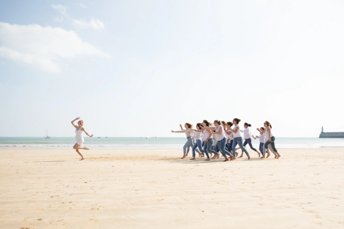 les filles courent après la future mariée sur la plage