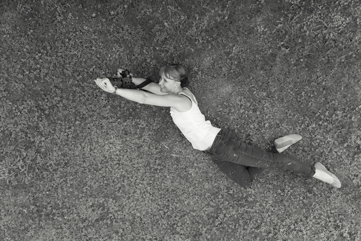 femme imitant superman allongée dans l'herbe