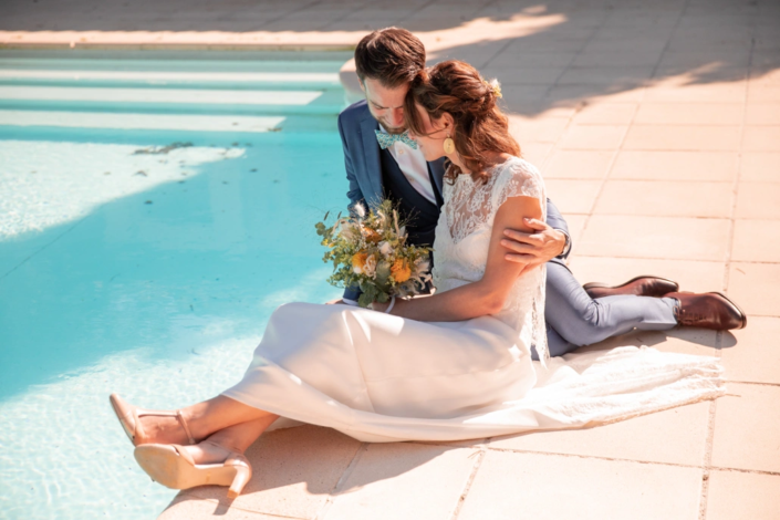 jeunes mariés au bord d'une piscine