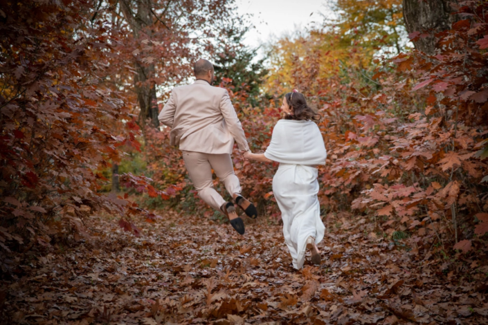 mariés courant dans une forêt l'automne