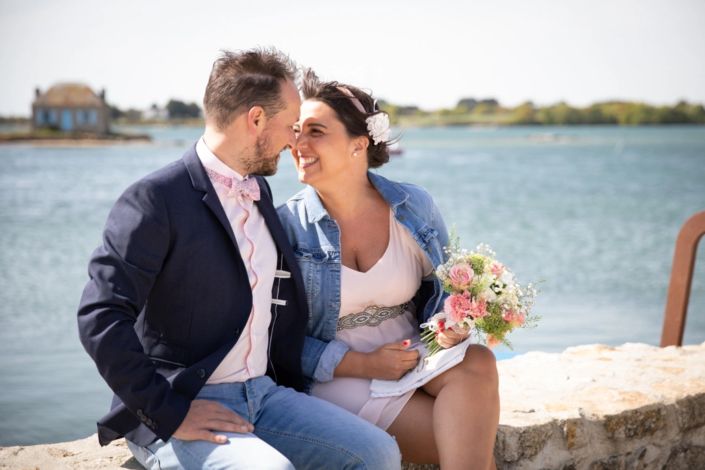 couple souriant assis sur un muret