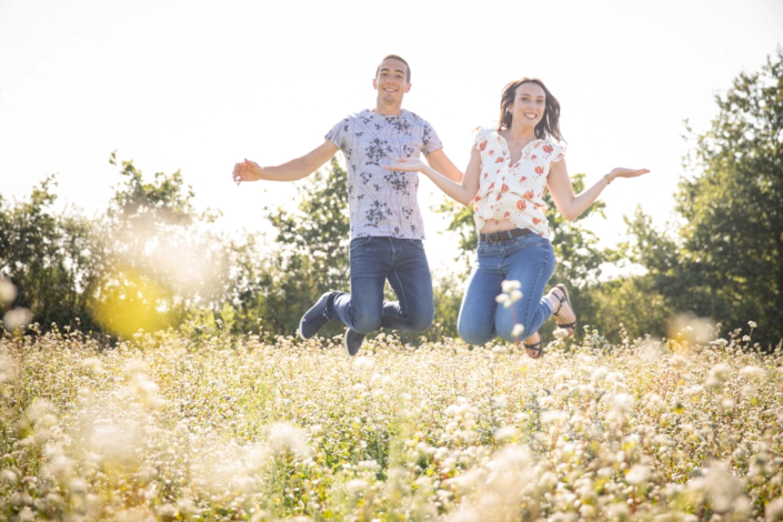 couple sautant dans un champ en fleur
